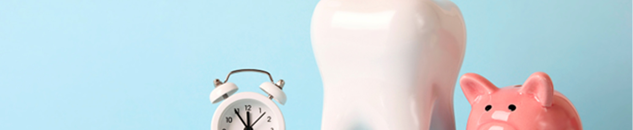 photo of an alarm clock, tooth-shaped cup with dental tools, and a piggy bank