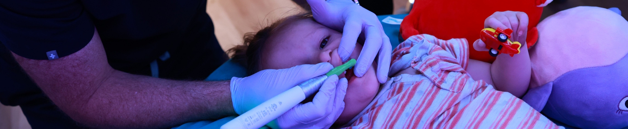 Pediatric dentist giving a child a dental checkup