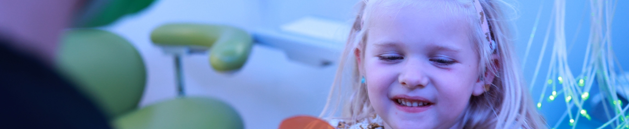 Young girl smiling in a dental office after pulp therapy in Denver
