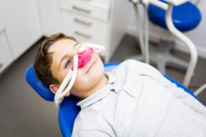 little boy with a nasal mask on in the dentist’s chair
