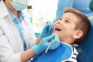 smiley little boy having his teeth checked for cavities